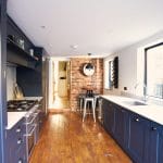 blue shaker kitchen with oak flooring