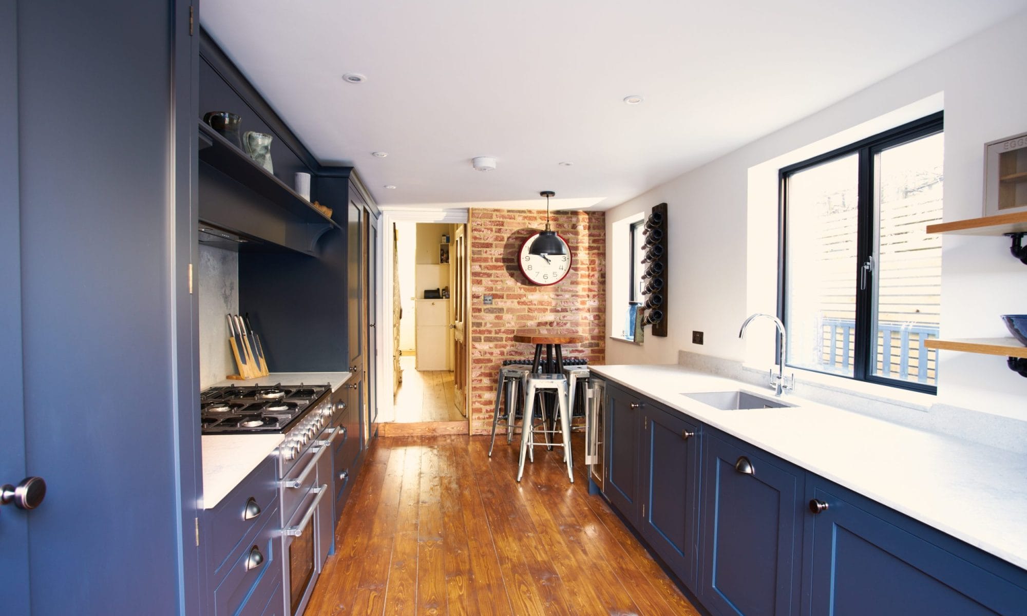 blue shaker kitchen with oak flooring