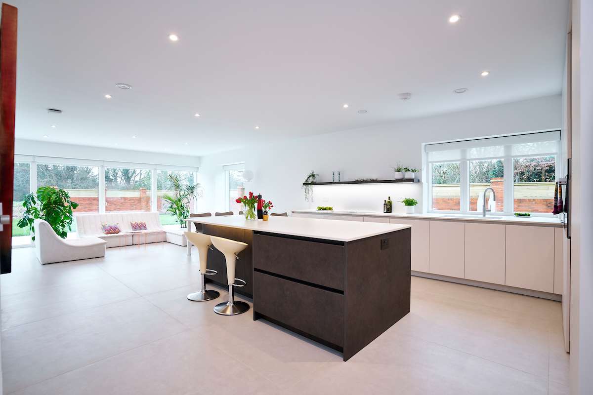 elegant breakfast bar with high-end white kitchen units and designer bar stools